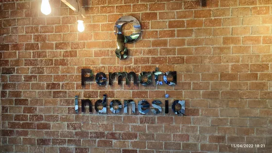 Huruf timbul stainless terpasang pada dinding bata fasad toko