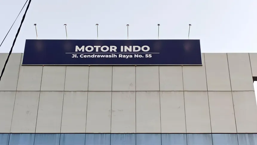 Signboard fasad toko dengan panel biru dan huruf putih