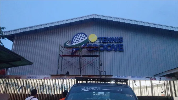 Signboard besar terpasang pada fasad gedung fasilitas olahraga