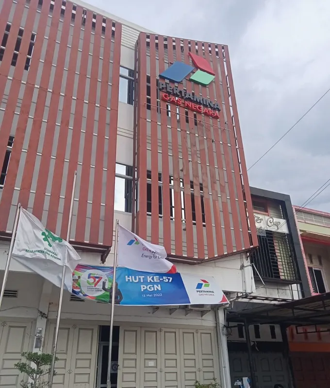 Fasad gedung perkantoran dengan panel dan penanda perusahaan