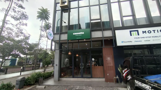 Signage gerai kopi terpasang pada fasad gedung