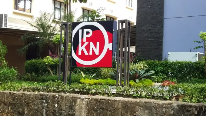 Neon box dua sisi berdiri di taman depan kantor