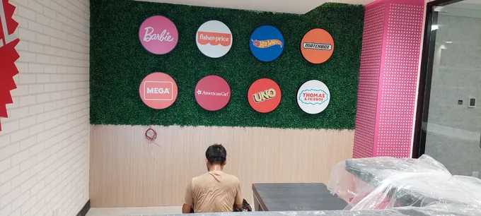 Panel merek berbentuk lingkaran terpasang pada dinding hijau kantor