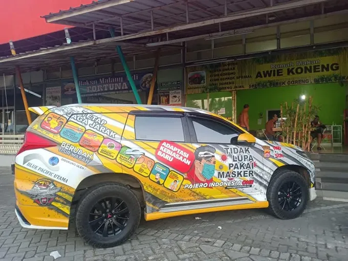 SUV dengan wrap penuh berisi pesan kampanye kesehatan berwarna kuning